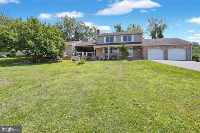 a view of a house with a yard and sitting area