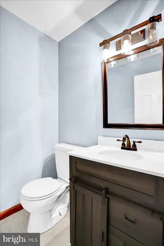 a bathroom with a toilet a sink and mirror
