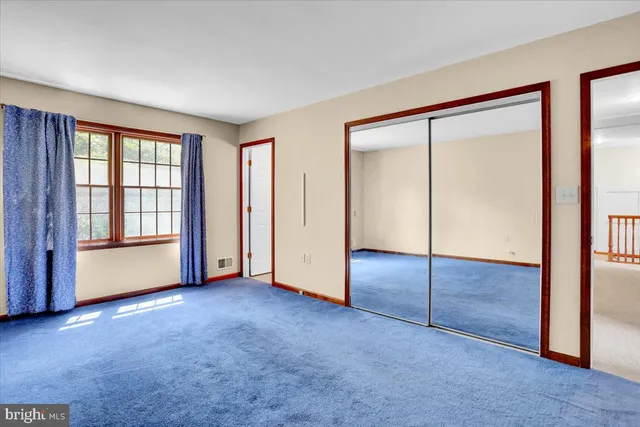 an empty room with windows and closet