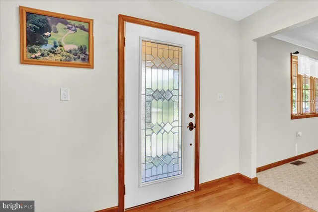 a view of a bedroom with wooden floor and a window