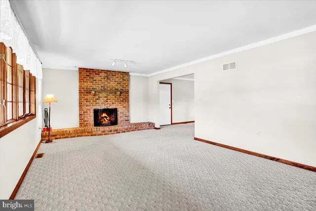 an empty room with fireplace and windows