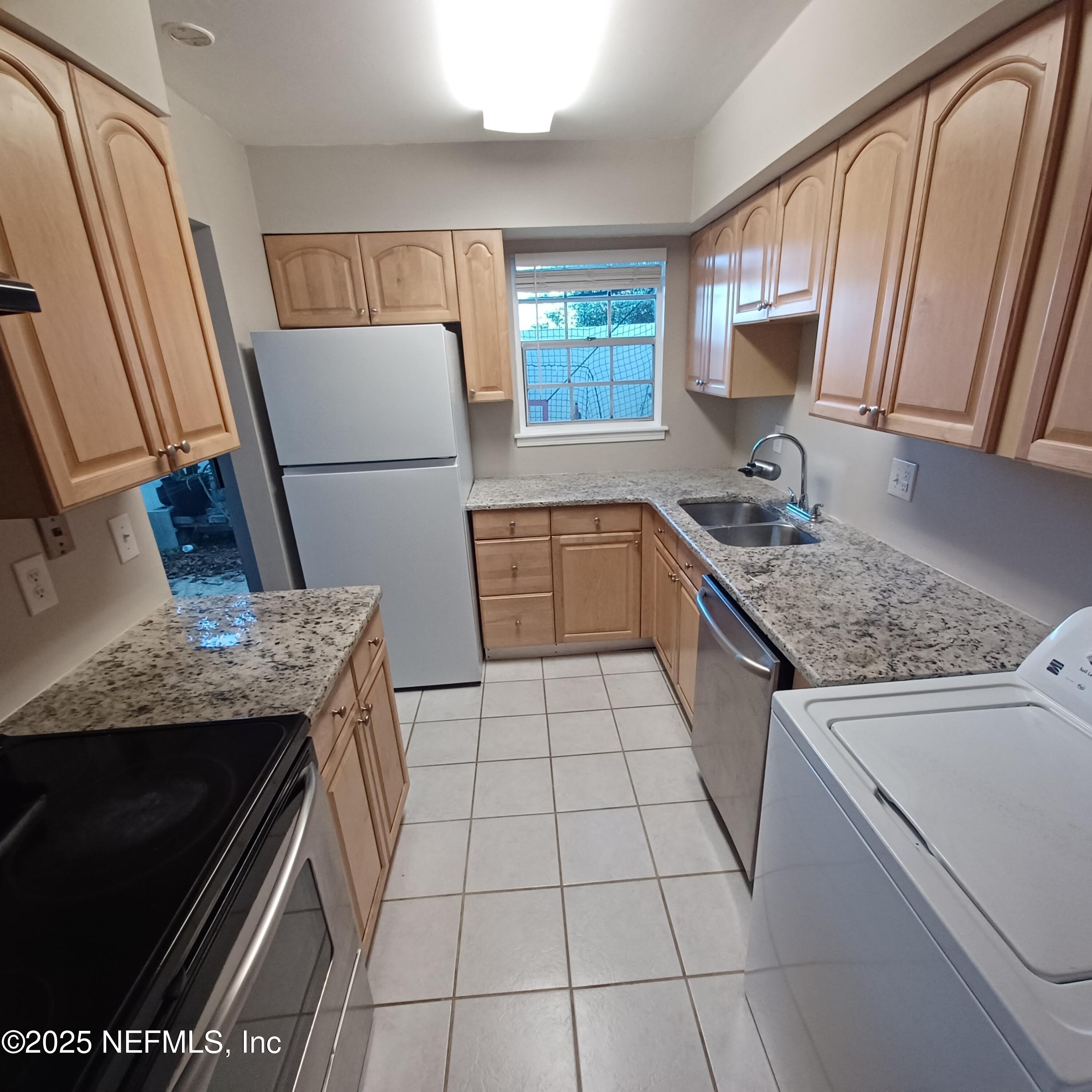 307 Kettering Terrace Orange Park, FL 32073 - Photo 5 of 16 a kitchen with a sink a stove top oven and cabinetry