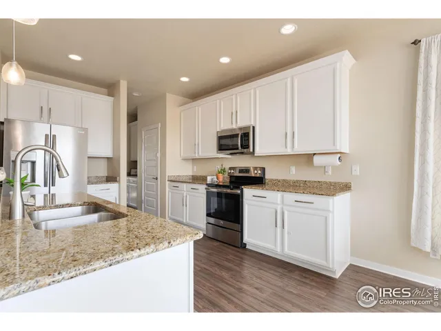 a kitchen with granite countertop a stove a sink and a microwave