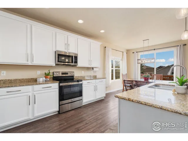 a kitchen with granite countertop white cabinets and white appliances
