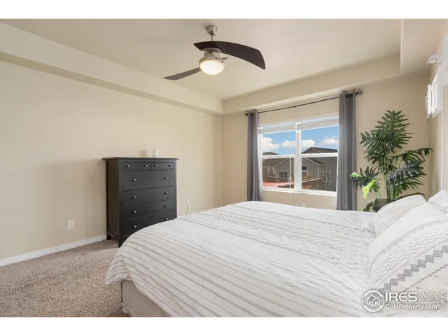 a bedroom with a bed and a large window