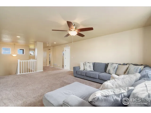 a living room with furniture and a ceiling fan