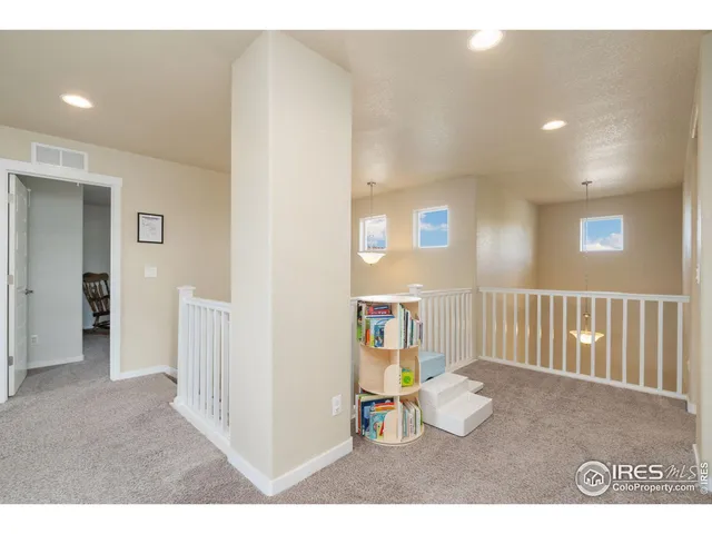 a view of a hallway with wooden floor and windows