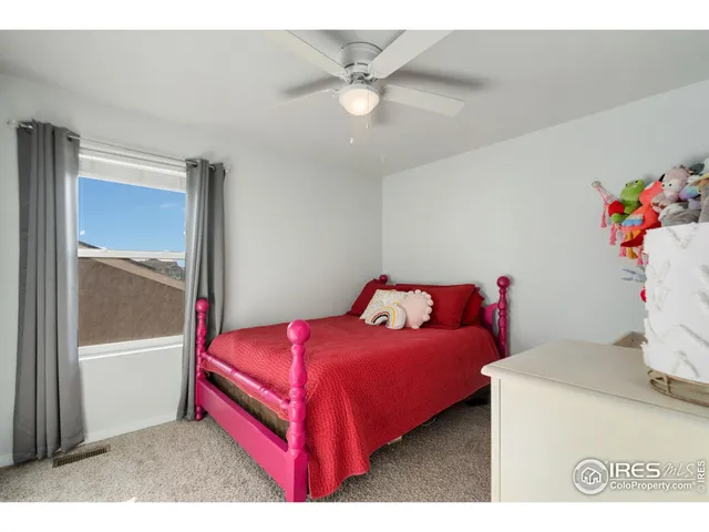a bedroom with a bed and a chandelier fan