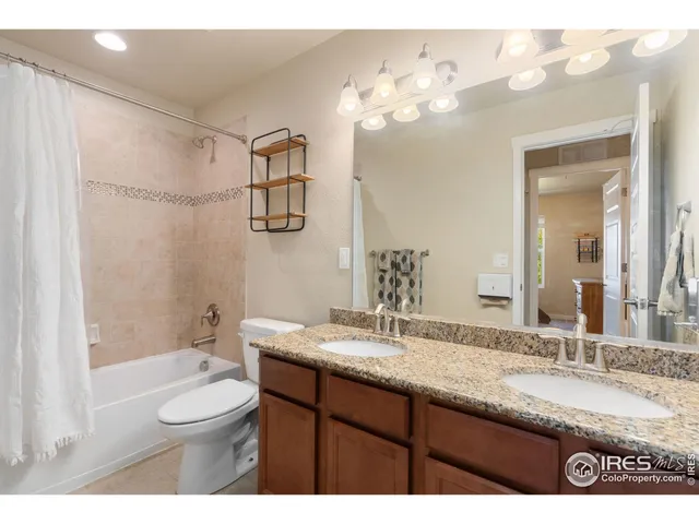 a bathroom with a granite countertop sink toilet a large mirror a bathtub and shower