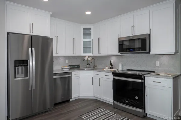 a kitchen with stainless steel appliances granite countertop a stove a refrigerator and a microwave