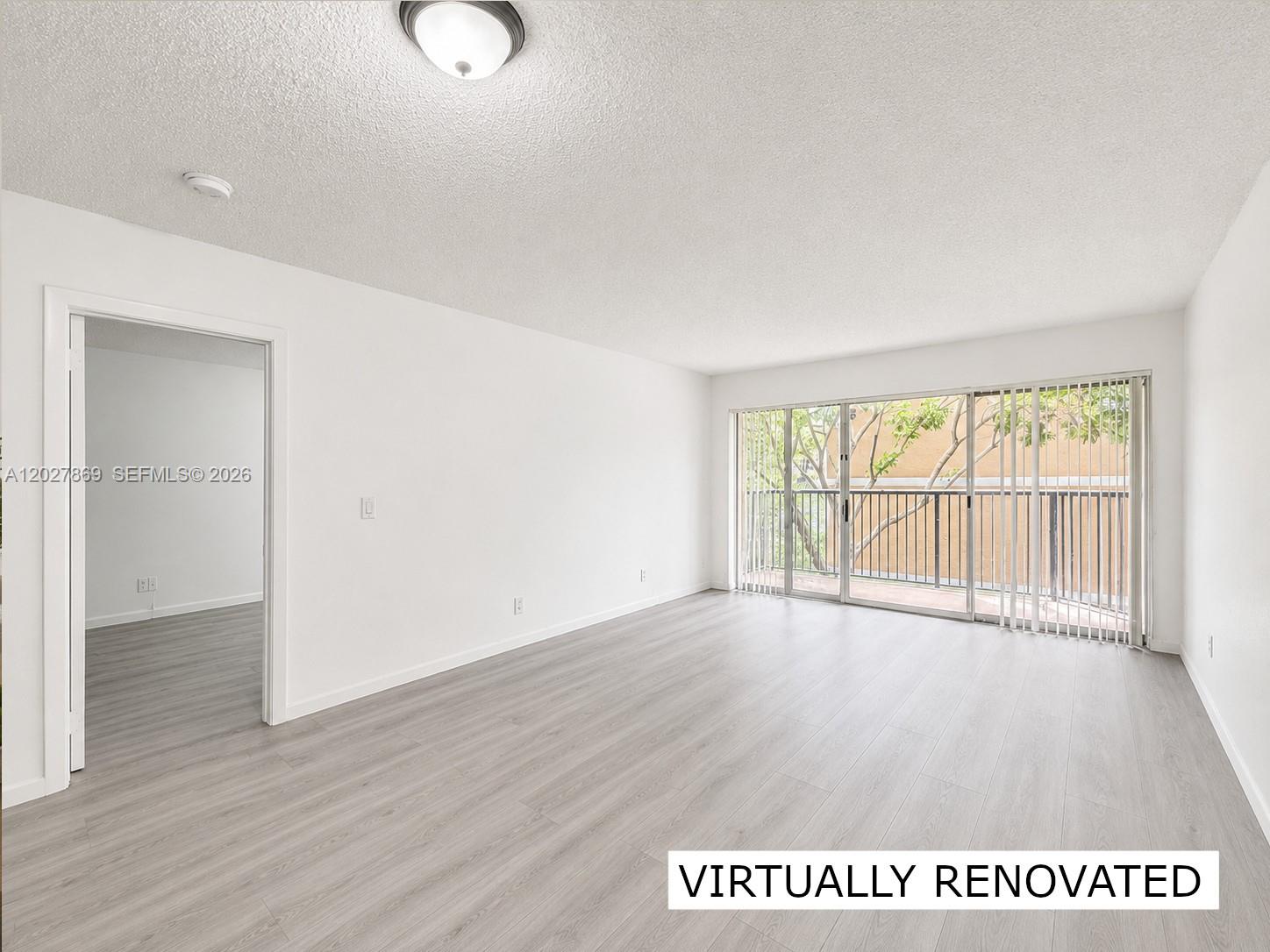 8761 Wiles Road, Unit 206 Coral Springs, FL 33067 - Photo 3 of 26 a view of an empty room with wooden floor and a window