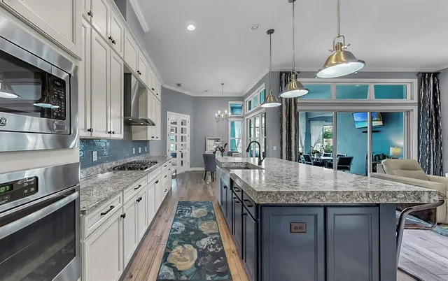 a kitchen with granite countertop a sink stainless steel appliances and cabinets