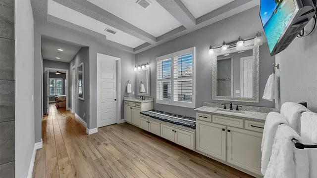 a bathroom with a double vanity sink and mirror with bathtub