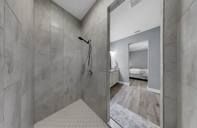 a spacious bathroom with a double vanity sink a mirror and a shower