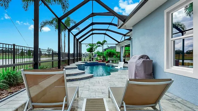 a outdoor space with chairs a couch and large windows