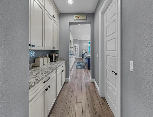 a large white kitchen with a sink and dishwasher a stove with wooden floor