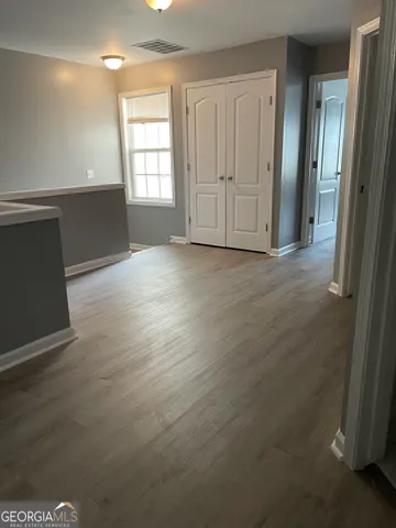 an empty room with wooden floor and windows