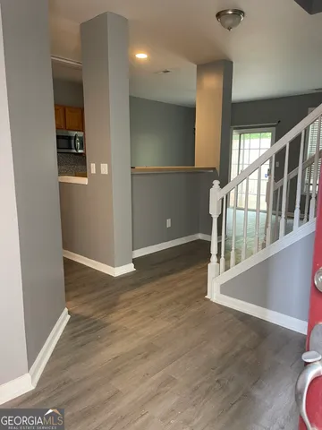 en empty room with wooden floor and windows