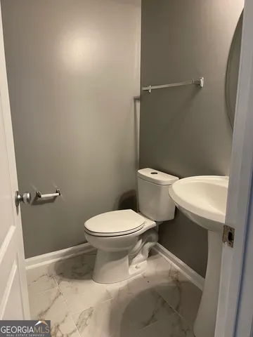 a white toilet sitting next to a bathroom sink and a shower