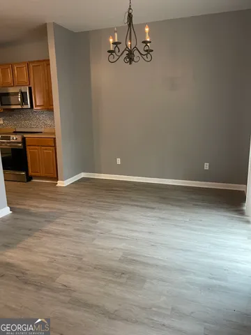 a view of a kitchen with wooden floor and stainless steel appliances