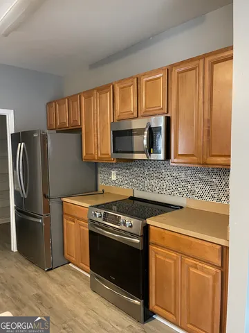 a kitchen with stainless steel appliances granite countertop a stove a refrigerator and a microwave