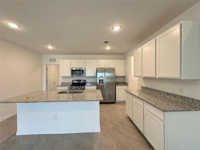a large kitchen with a large counter top appliances and cabinets