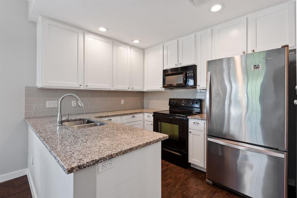 1748 Ohlen Road, Unit 22 Austin, TX 78757 - Photo 11 of 14 Kitchen featuring granite countertops, white cabinetry, a subway tile backsplash, stainless steel refrigerator, and wood-finish flooring