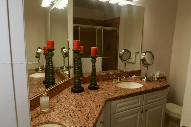 a bathroom with a granite countertop sink a mirror and shower