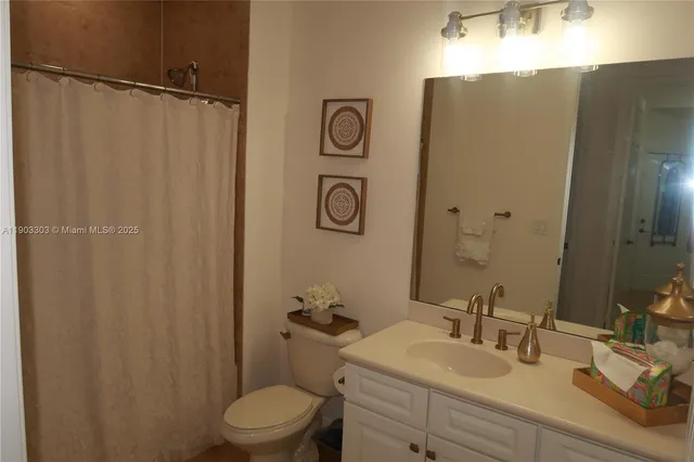 a bathroom with a granite countertop sink toilet and a mirror