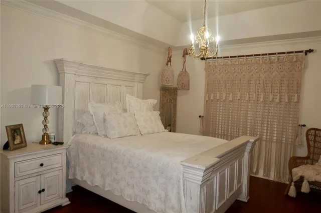 a spacious bedroom with a bed and a chandelier