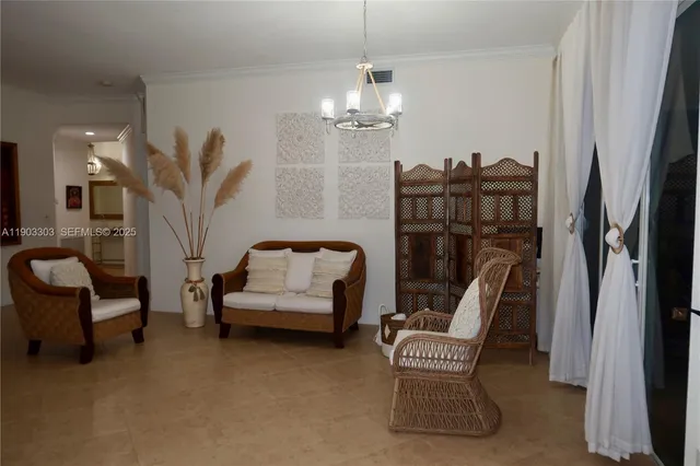 a living room with furniture a chandelier and a chair