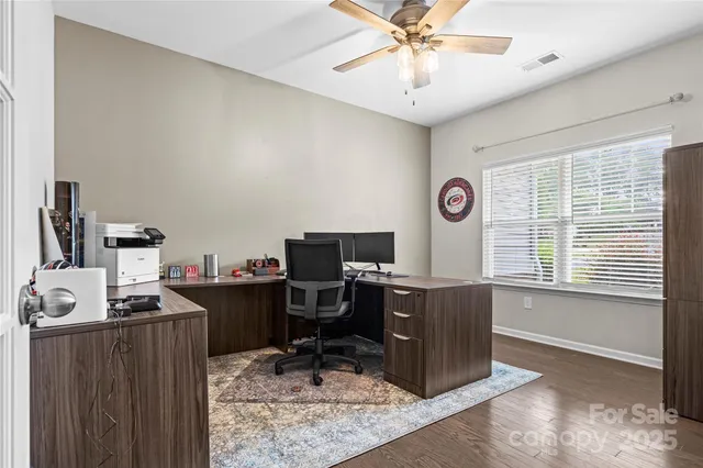 a view of a workspace with furniture and a window