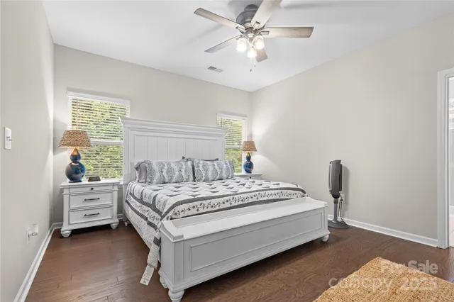 a bedroom with a bed chandelier and a window