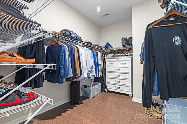 a view of walk in closet with clothes and shoes