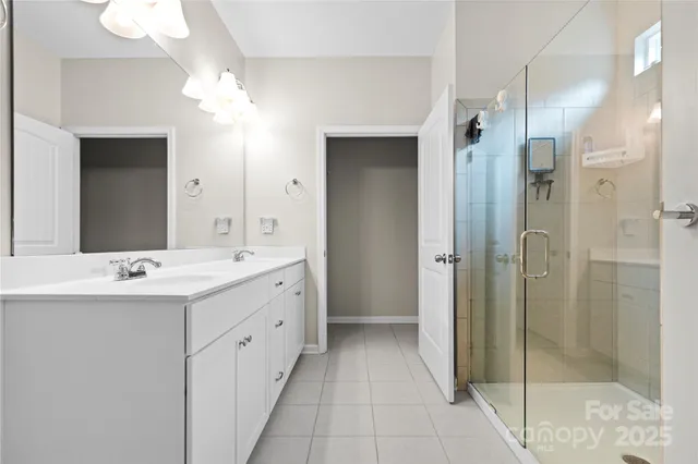 a bathroom with a double vanity sink mirror and shower