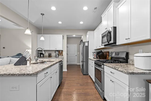 a kitchen with stainless steel appliances granite countertop a sink stove and refrigerator