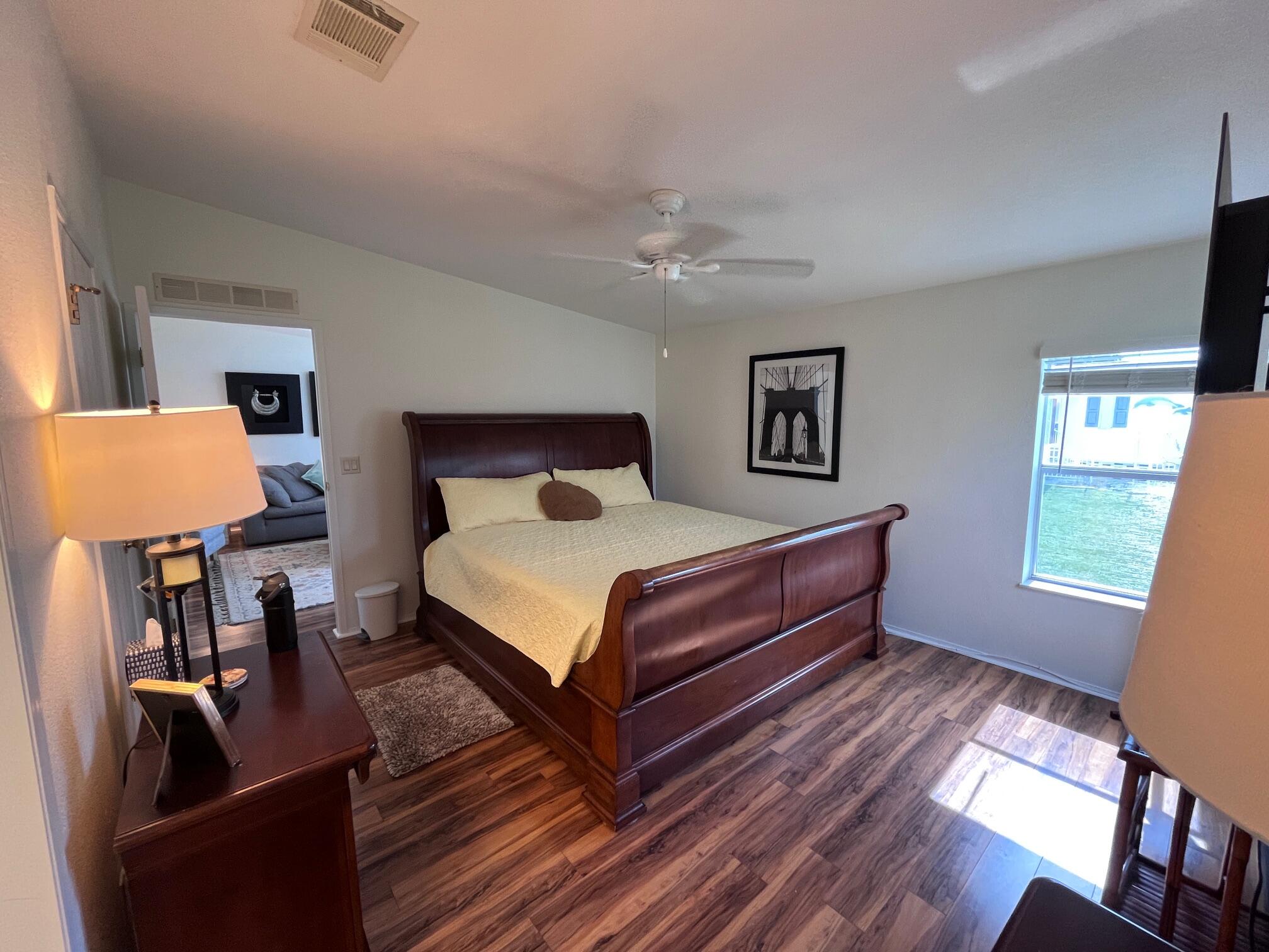 65 Turquoise Avenue Naples, FL 34114 - Photo 29 of 34 a spacious bedroom with a bed and wooden floor