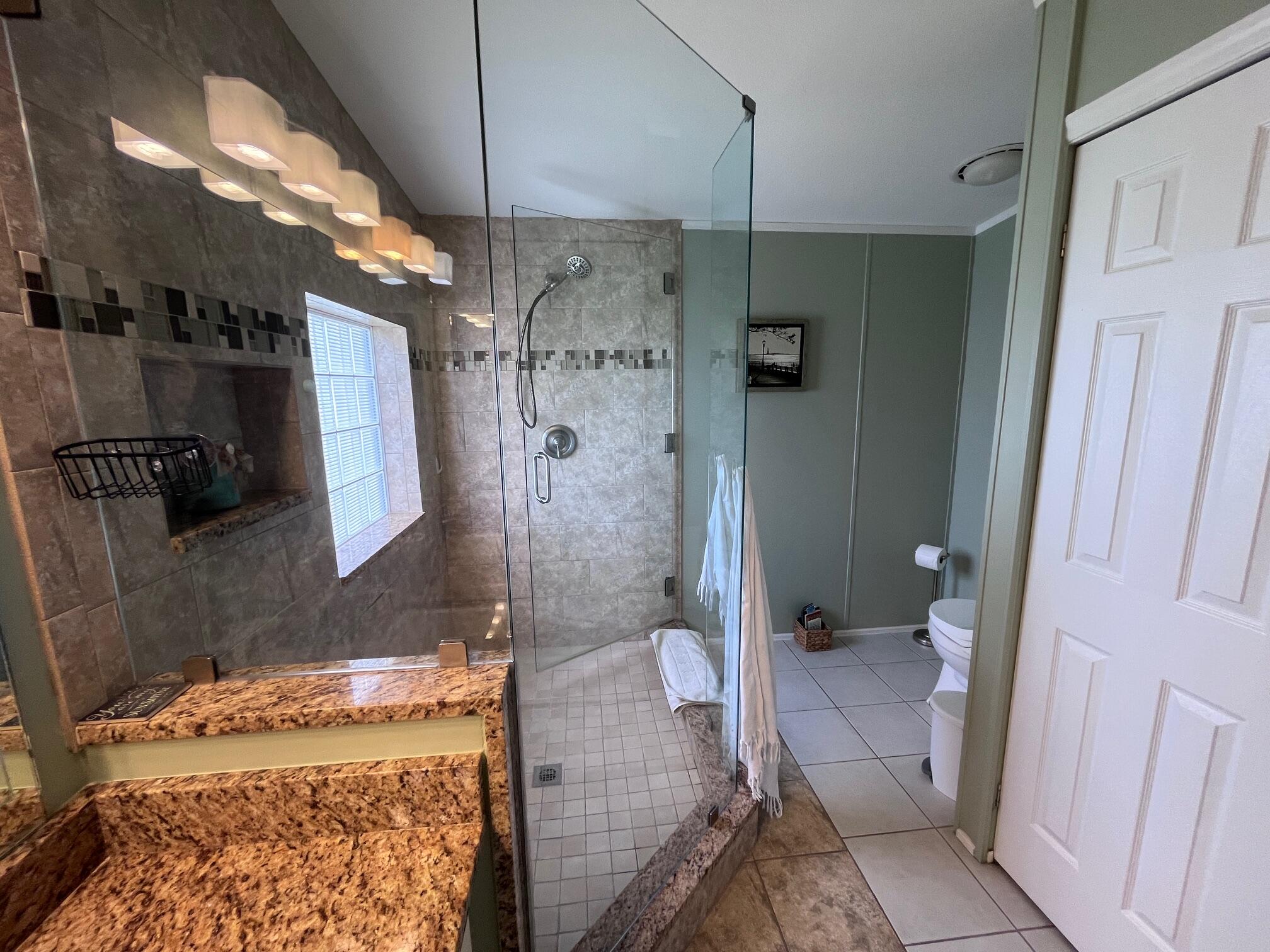 65 Turquoise Avenue Naples, FL 34114 - Photo 31 of 34 a bathroom with a granite countertop shower a sink and a toilet
