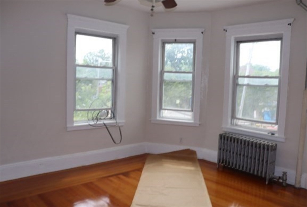 310 Talbot Avenue, Unit 2 Boston, MA 02124 - Photo 12 of 16 an empty room with wooden floor and windows