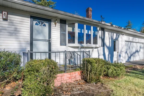 a view of a porch with a floor to ceiling window and potted plants