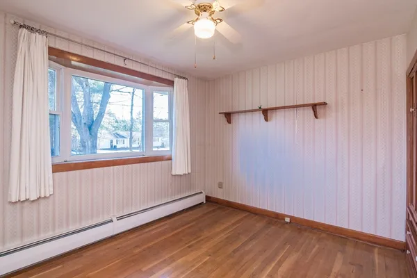 wooden floor in an empty room with a window