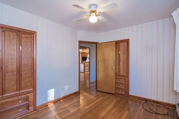 an empty room with closet and a chandelier fan