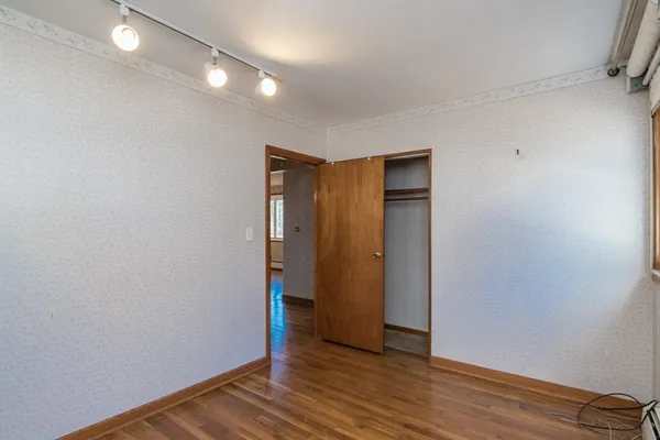 a view of an empty room with wooden floor
