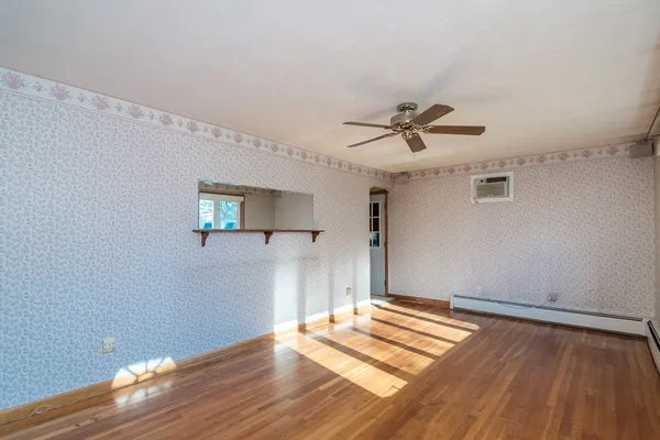 a view of a livingroom with wooden floor and a ceiling fan