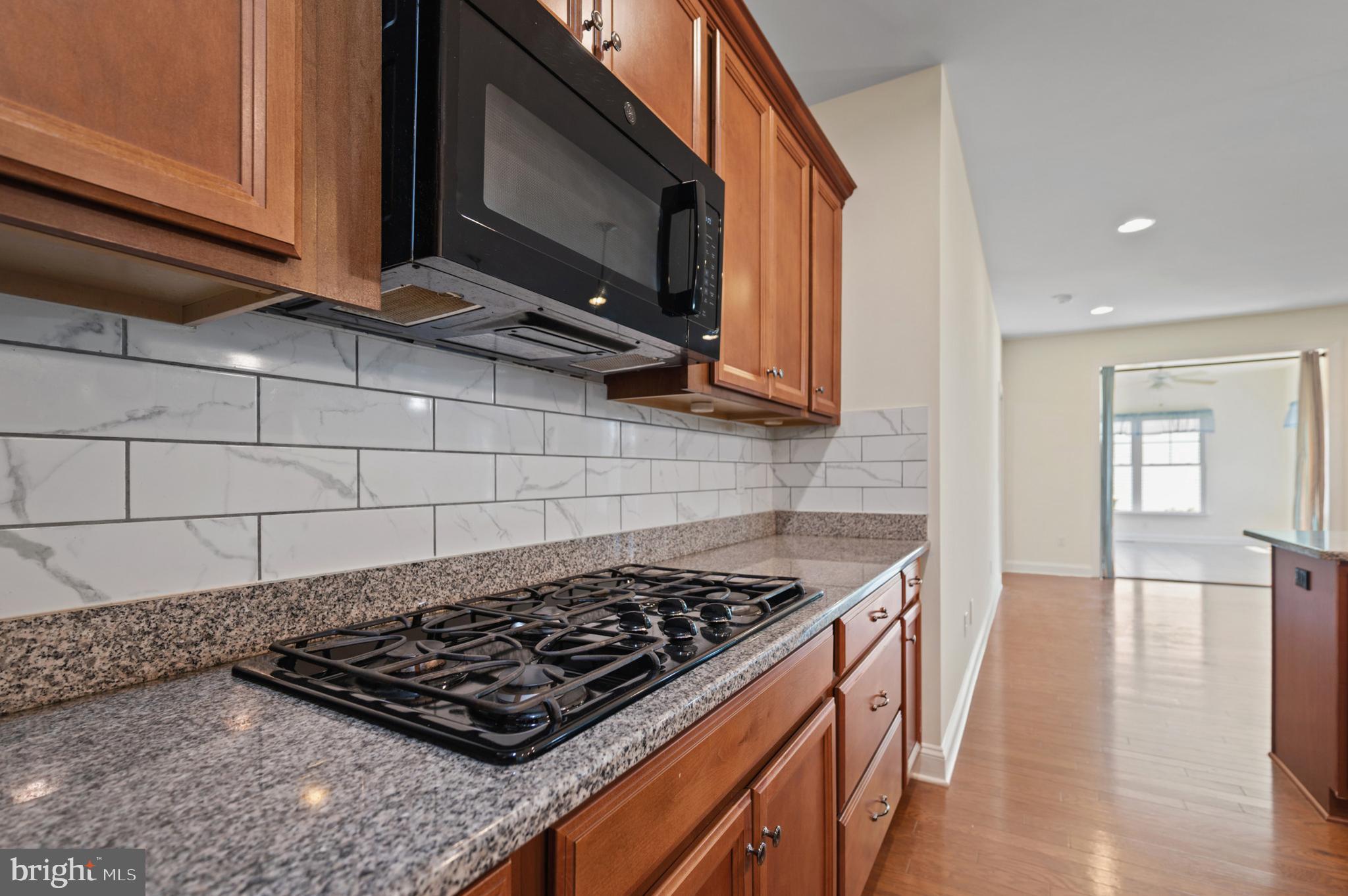 33301 Bayberry Court Dagsboro, DE 19939 - Photo 14 of 44 a kitchen with a stove a sink and a microwave
