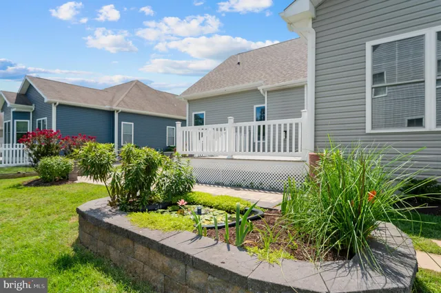 a front view of a house with a yard and potted plants