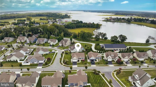 an aerial view of residential houses with outdoor space and lake view