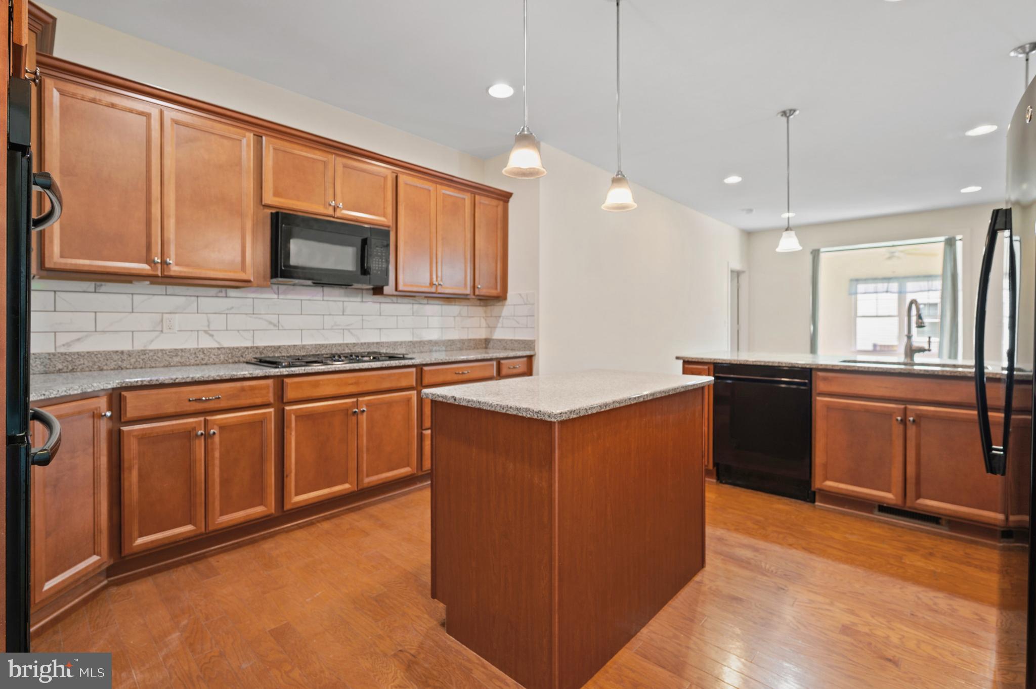 33301 Bayberry Court Dagsboro, DE 19939 - Photo 4 of 44 a kitchen with stainless steel appliances granite countertop a stove a sink and a microwave