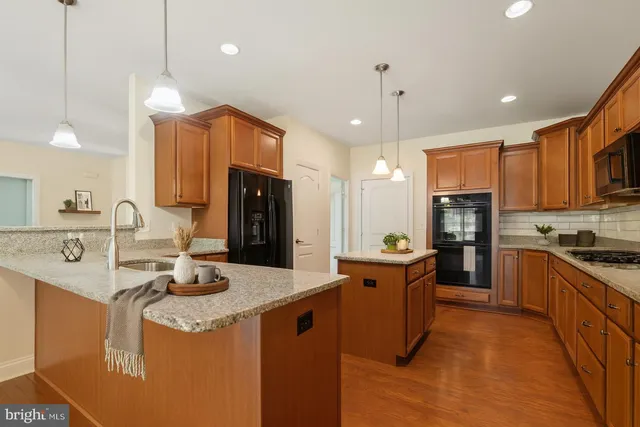 a kitchen with stainless steel appliances granite countertop a sink a stove and a refrigerator