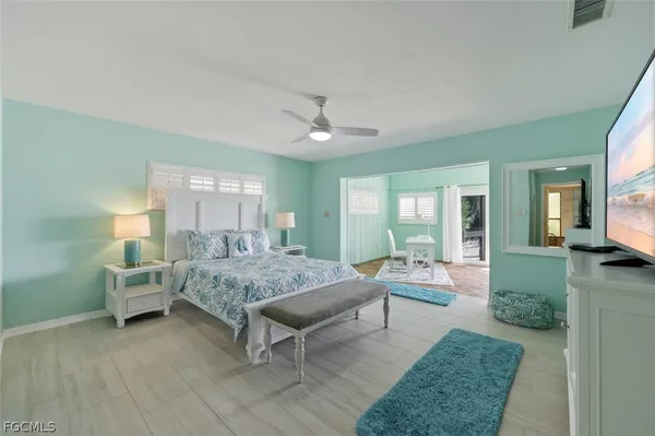 a bedroom with a bed and large windows